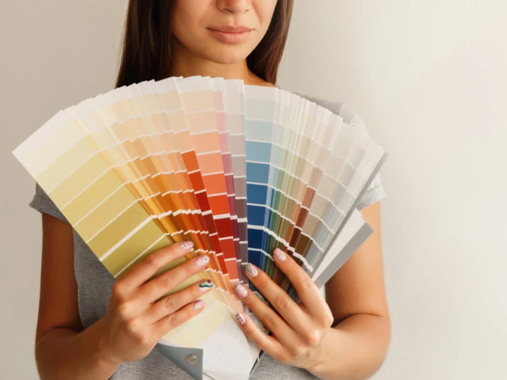 Une femme tient un nuancier de couleurs pour sélectionner la palette graphique et le logo d'un commerce de proximité à Bellême