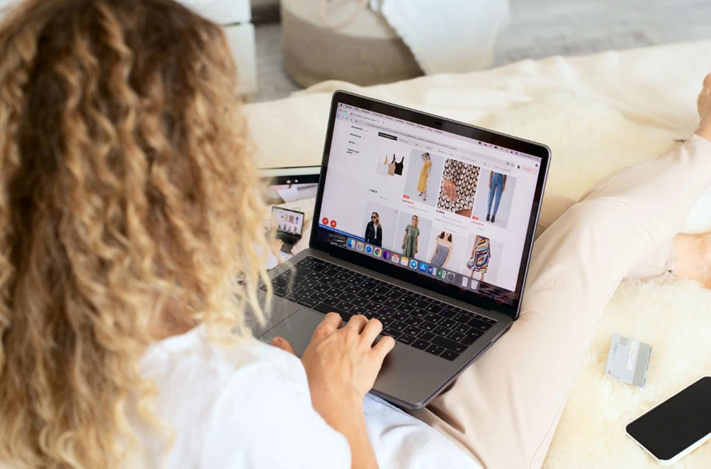 Cliente consultant une boutique de vêtements en ligne sur son téléphone avant de choisir l'option click and collect en Eure-et-Loir.
