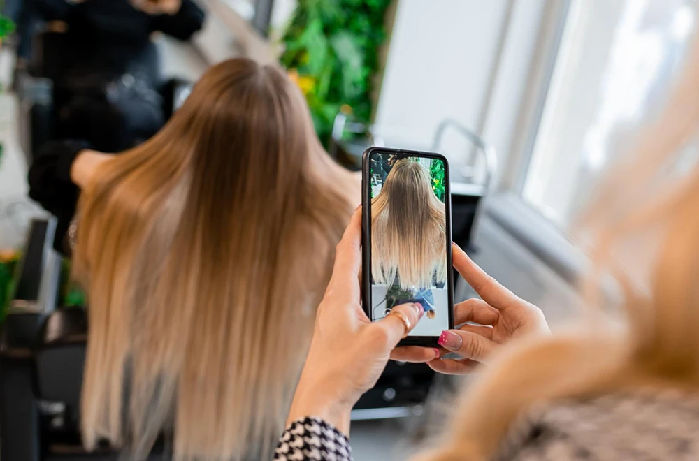 Une coiffeuse du Mans rédigeant une publication Instagram pour son salon de coiffure